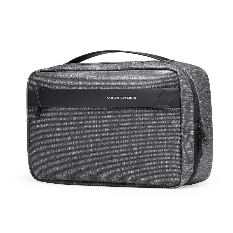 A dark gray waterproof travel toiletry bag with a black handle and a name tag displaying MARK RYDEN.