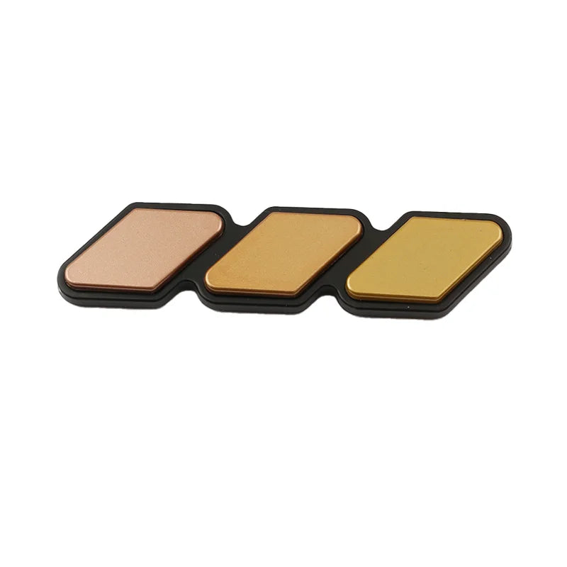 A set of three rectangular grille emblem stickers in copper, gold, and black for Toyota trucks and SUVs