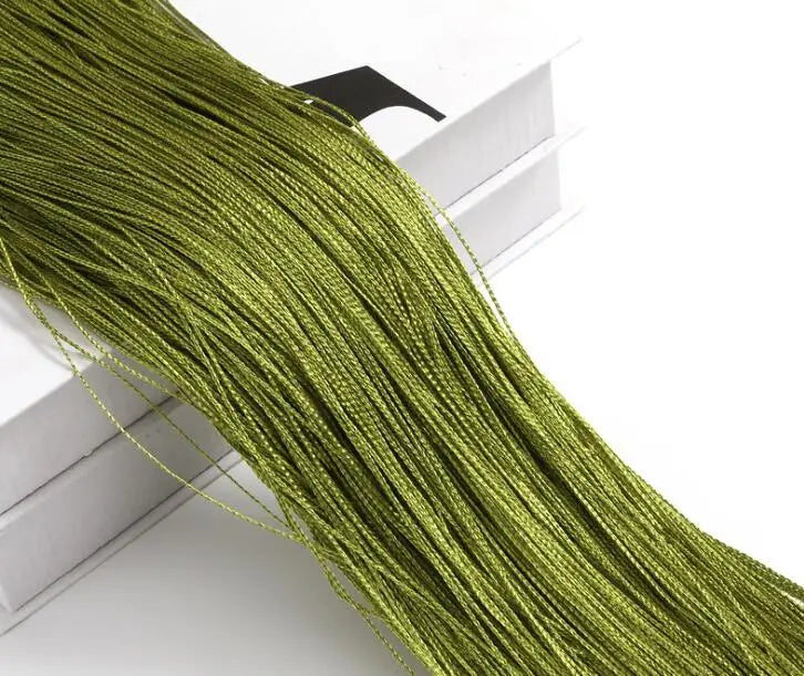 A close-up of a long, thick, olive green beaded thread curtain hanging down.