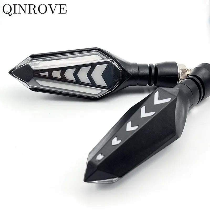 A black motorcycle turn signal indicator with a clear lens and chevron pattern.