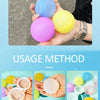A hand is filling a colorful reusable splash water balloon with water.