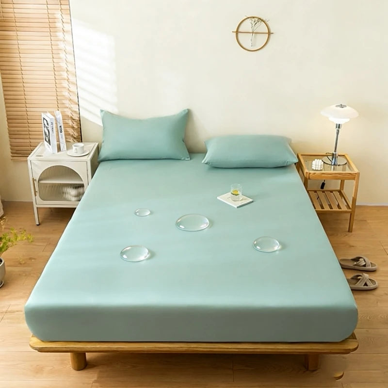Una funda protectora impermeable de color azul claro se extiende sobre un marco de cama de madera en una habitación luminosa.