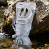 A clear collapsible hydration bladder is submerged in clear water next to a large rock.
