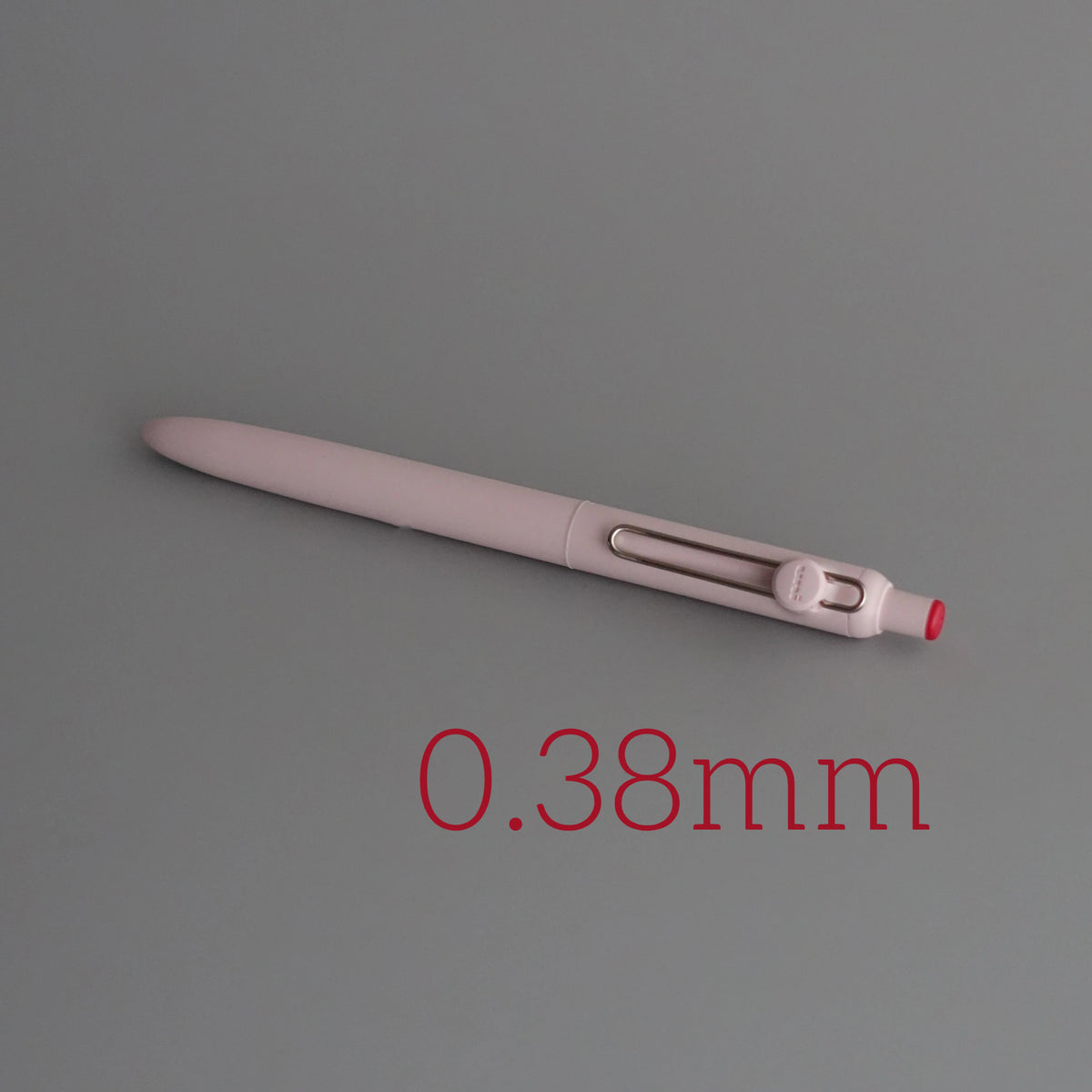 A close-up view of a light pink Uni ZENTO Quick-Dry Gel Pen with a 0.38mm tip.