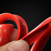 A hand is holding a red car wheel rim protector trim, showing its curved shape and texture against a dark background.