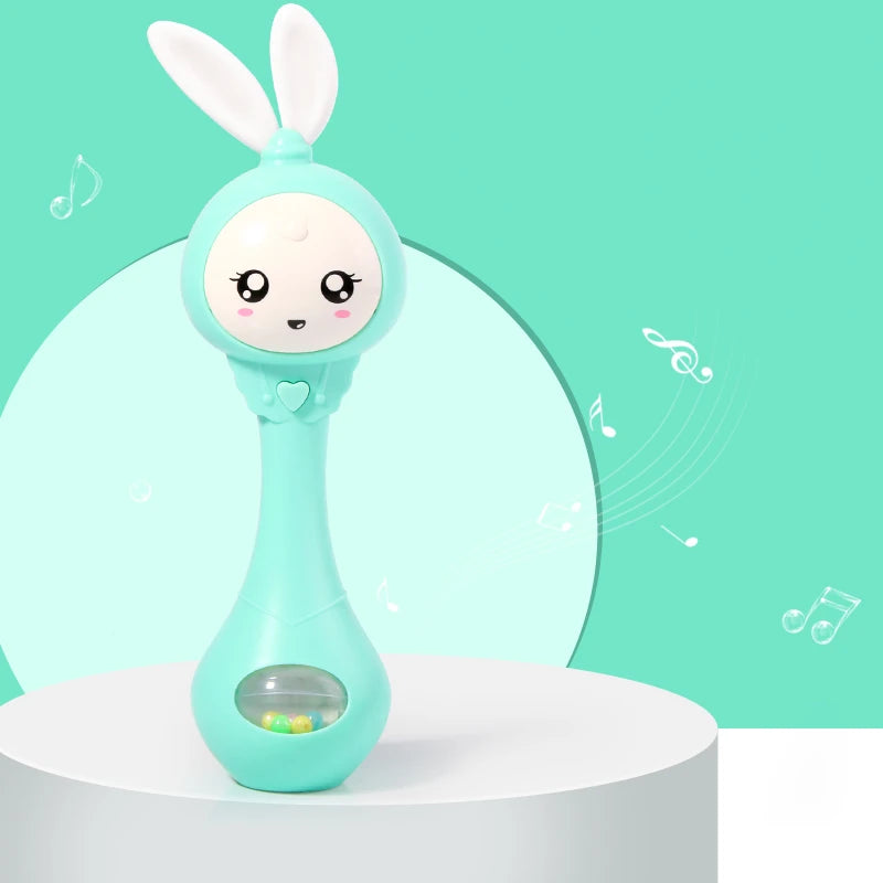 A light blue musical rabbit rattle and teether toy is displayed on a white surface against a teal background.