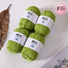 A stack of bright green Milk Cotton yarn balls with white labels and a pink circle marked #18.
