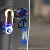 A close-up of a CNC machined titanium motorcycle key head cover keychain with a blue iridescent finish.