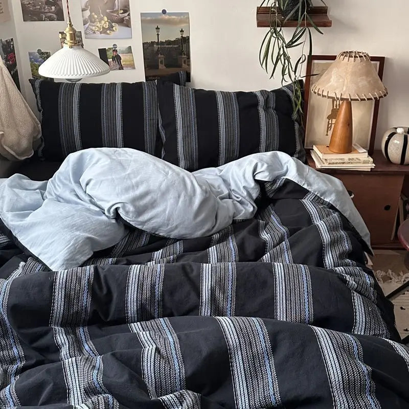 Black and gray plaid bedding set featuring a duvet cover, flat sheet, and pillowcases.