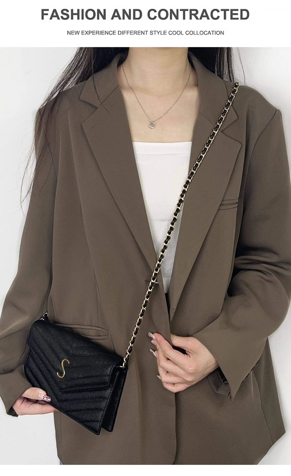 A woman models a dark olive blazer with a gold chain strap for a crossbody bag.