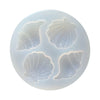 A silicone mold set featuring four detailed sea creatures, including a shell and starfish, for cake decorating.