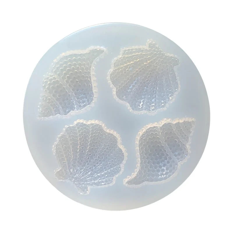 A silicone mold set featuring four detailed sea creatures, including a shell and starfish, for cake decorating.
