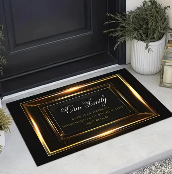 Elegentliche goldgerahmte Fußmatte mit 'Unsere Familie'-Inschrift auf einem dunkelgrauen Eingangsboden.