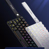 Nahaufnahme einer schwarzen mechanischen Tastatur mit weißen Tastenkappen und einem separaten NACODEX-Switch daneben.