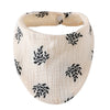 A beige organic cotton muslin baby bib with a gathered band for absorbent use, featuring a black leafy print.