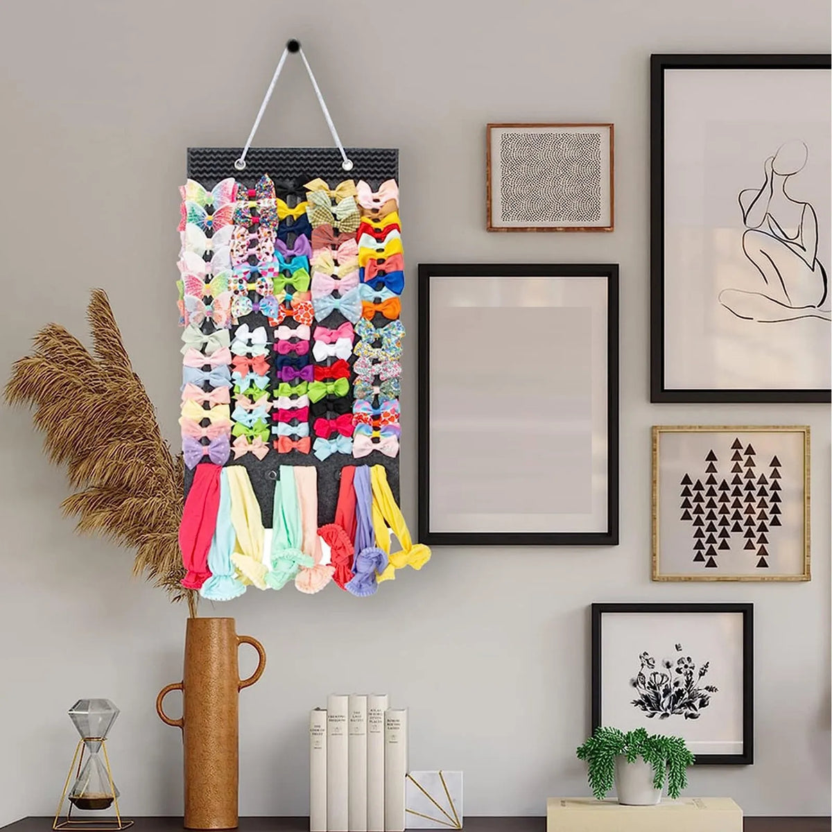 A large capacity hair bow and clip organizer with a rope hanger displaying colorful bows and clips on a wall.