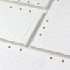 Close-up view of loose leaf notebook refill paper sheets with ruled lines and dotted guides.