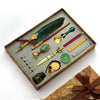 A vintage calligraphy fountain pen set with a wax seal stamp kit displayed in a wooden box.