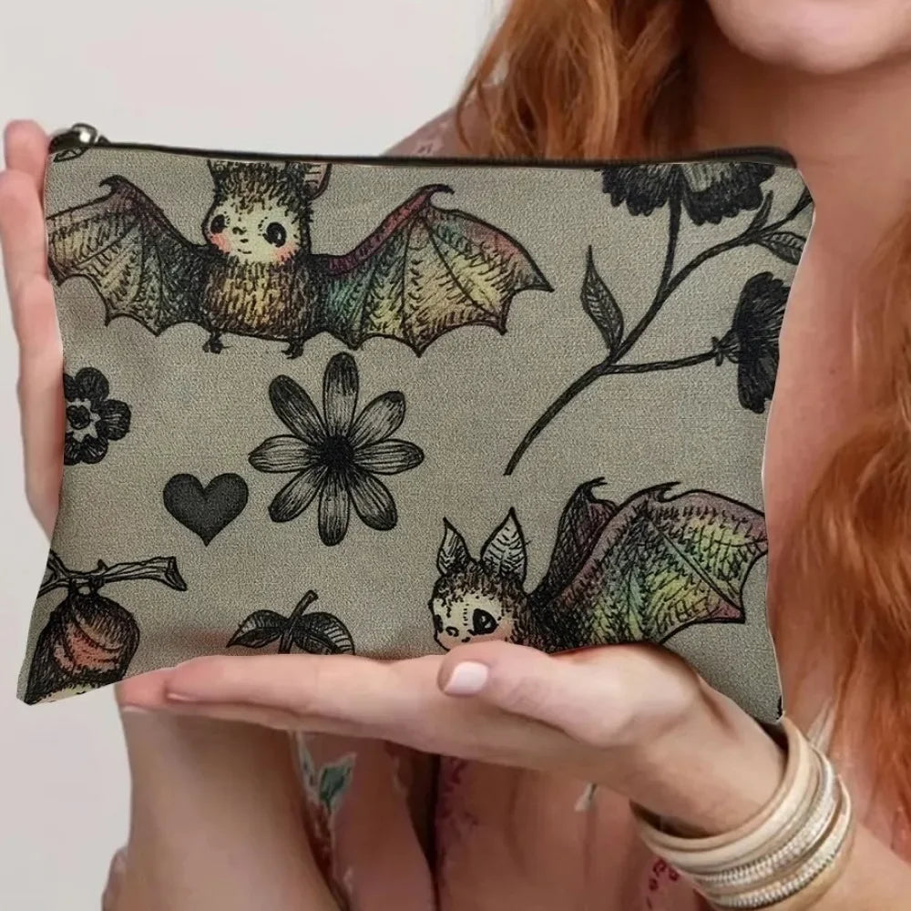 A dark gray canvas storage pouch featuring a silhouette of a bat and a flower.