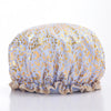 A reusable elastic shower cap for women in a light purple fabric with gold leopard print detailing.