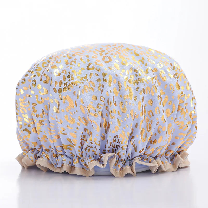 A reusable elastic shower cap for women in a light purple fabric with gold leopard print detailing.
