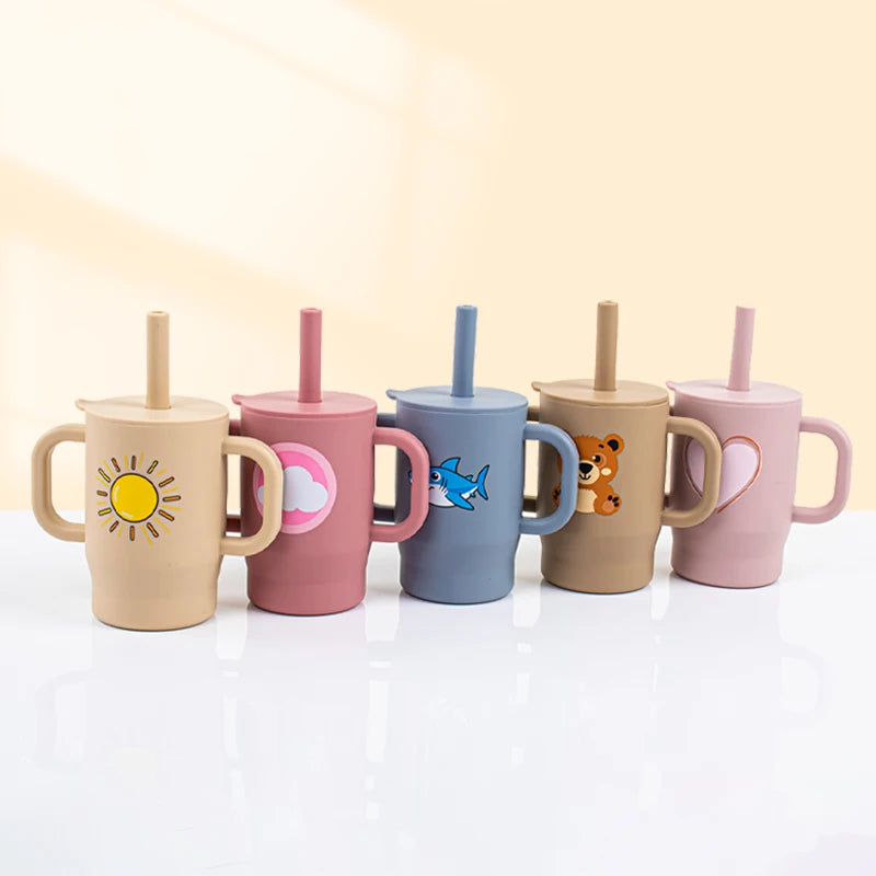A set of five silicone training cups with straws and handles in various pastel colors featuring sun, clouds, fish, and bear d