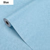 Roll of blue embossed silk self-adhesive wallpaper being peeled from its backing