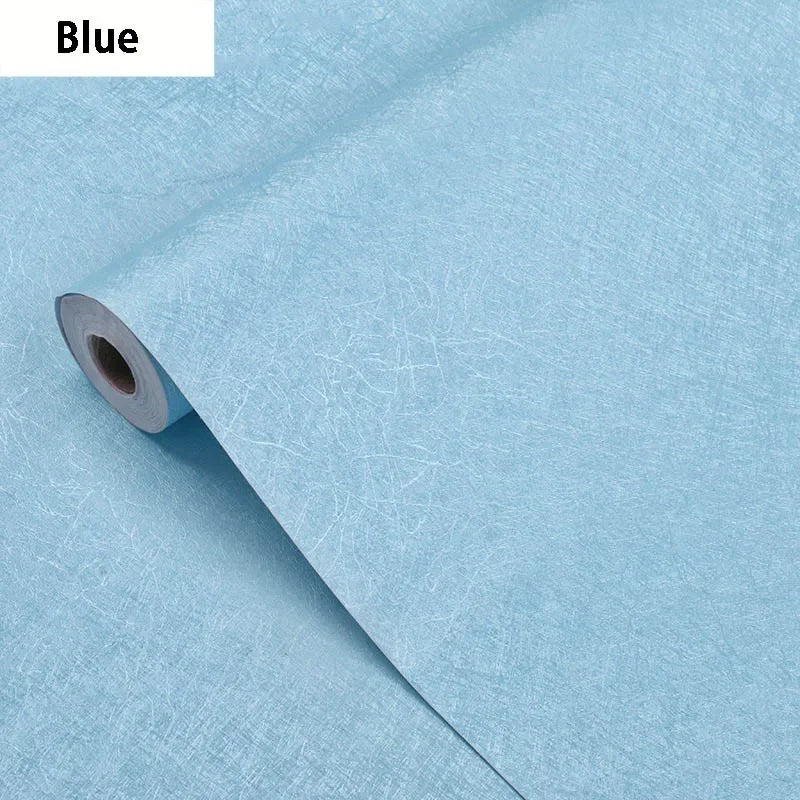 Roll of blue embossed silk self-adhesive wallpaper being peeled from its backing