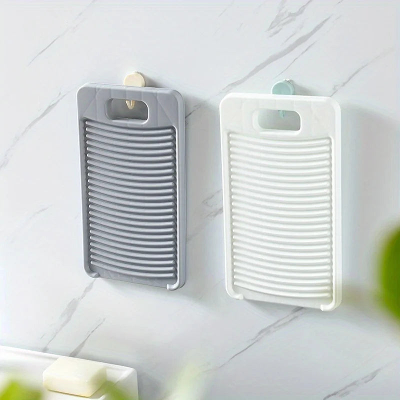 A gray and white non-slip laundry scrubbing board mounted on a wall.