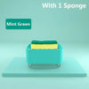 Mint green kitchen soap dispenser with a yellow sponge inside