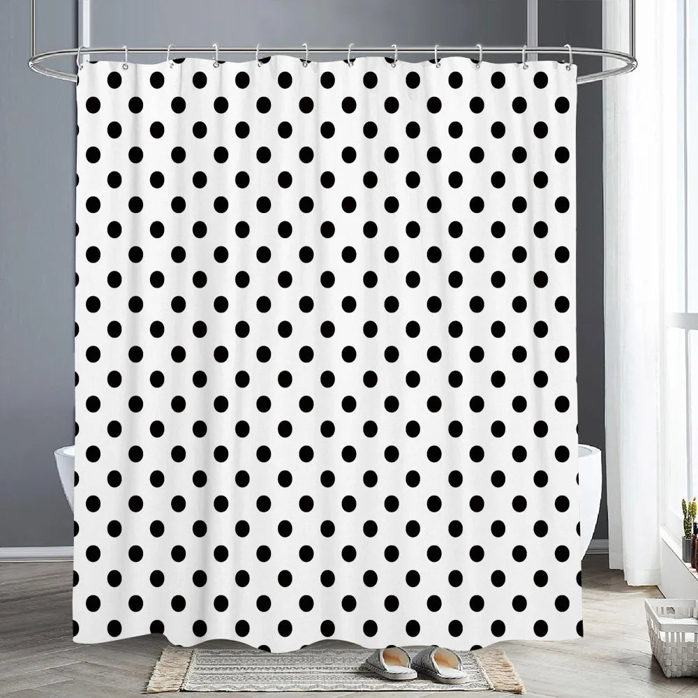 A white shower curtain with a black polka dot pattern hanging on a metal rod.