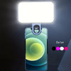 A smartphone is illuminated by a portable clip-on LED light, displaying a gradient color effect.