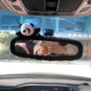 A close-up view of a car's interior rearview mirror showing a plush bear and pig design.