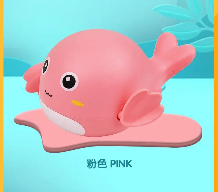 A pink cartoon whale bath toy resting on a pink mat.