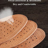 Three brown genuine leather insoles are shown on a dark wooden surface, emphasizing their breathable and comfortable features