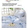 A light blue quilted blanket with a floral pattern is displayed on a bed, emphasizing gentle and cute healing life.