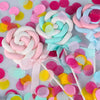 Nahaufnahme von Papierschnipseln in Pastellfarben wie Rosa, Blau und Gelb in Rosettenform.