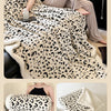 A leopard print plush jacquard throw blanket draped over a sofa and shown in various close-up views.