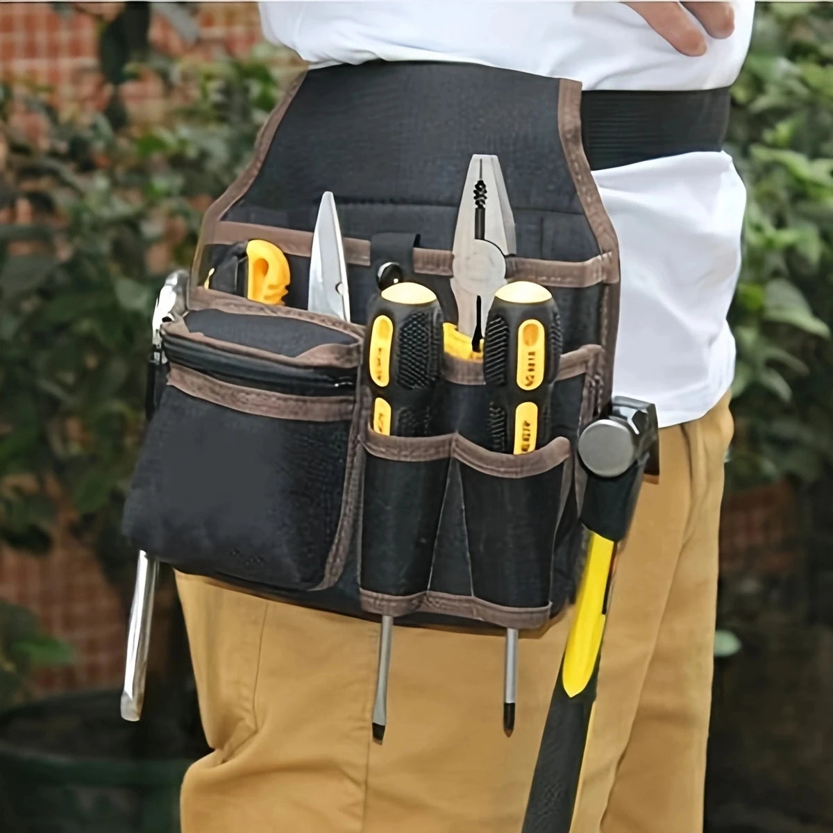 A black heavy-duty tool waist bag with multiple pockets is worn by a person, featuring various tools and knives.