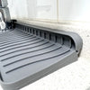 A gray silicone faucet splash mat designed to catch water on a countertop.