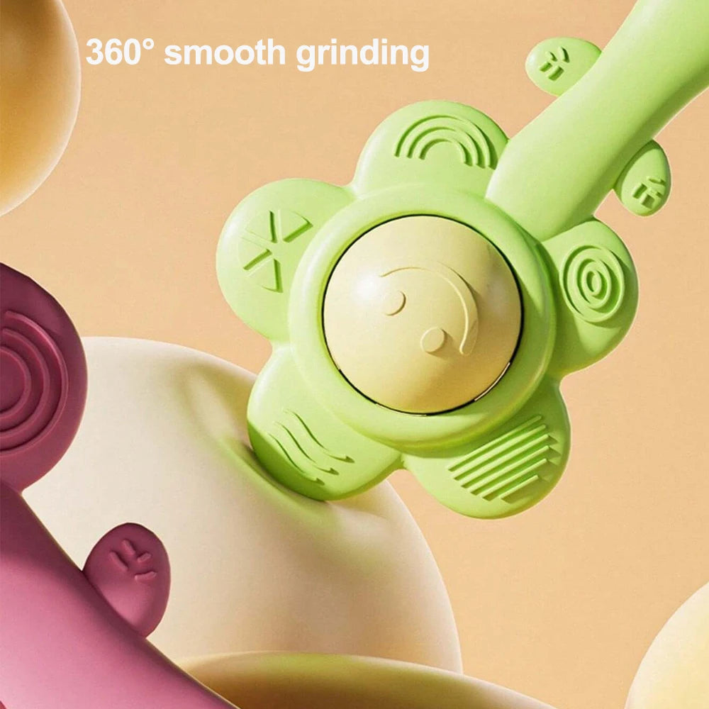 A close-up of a light green baby teething rattle with a smooth grinding feature and a yellow grip component.