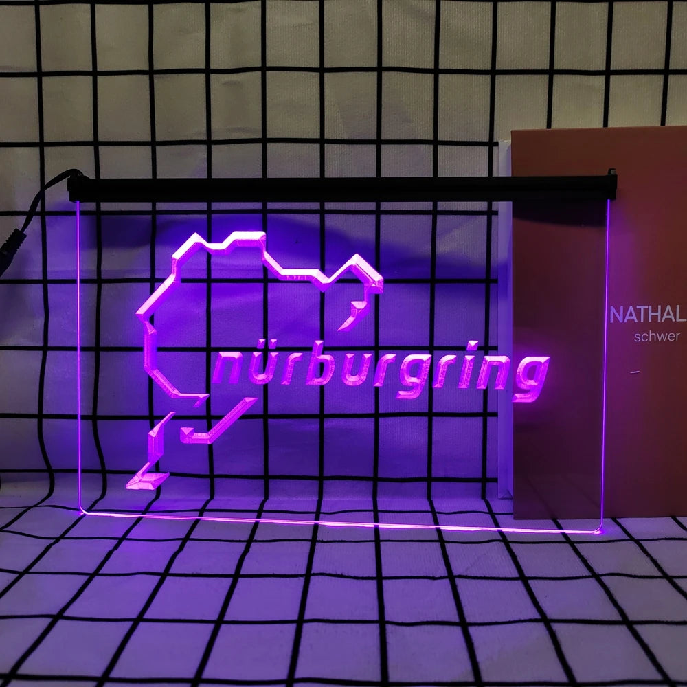 A neon sign shaped like a stylized mountain outline with the word Nürnbergg glowing purple against a grid background.