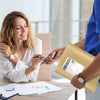 A woman is sealing a kraft bubble mailer with self-seal adhesive in an office setting.