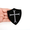 Black shield-shaped embroidered patch featuring a silver cross design for Knights Templar
