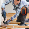 A person is installing wooden flooring, using a tool to secure a plank, while wearing heavy-duty gel knee pads.