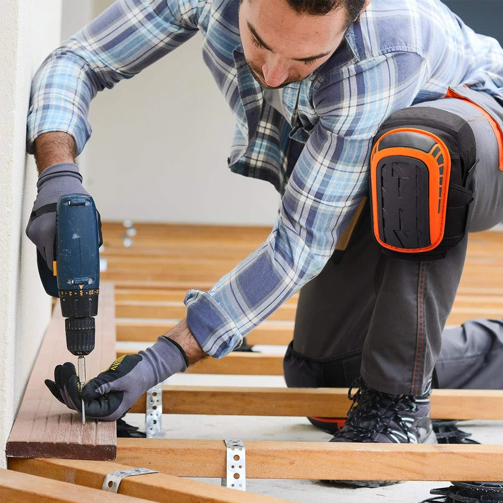 A person is installing wooden flooring, using a tool to secure a plank, while wearing heavy-duty gel knee pads.