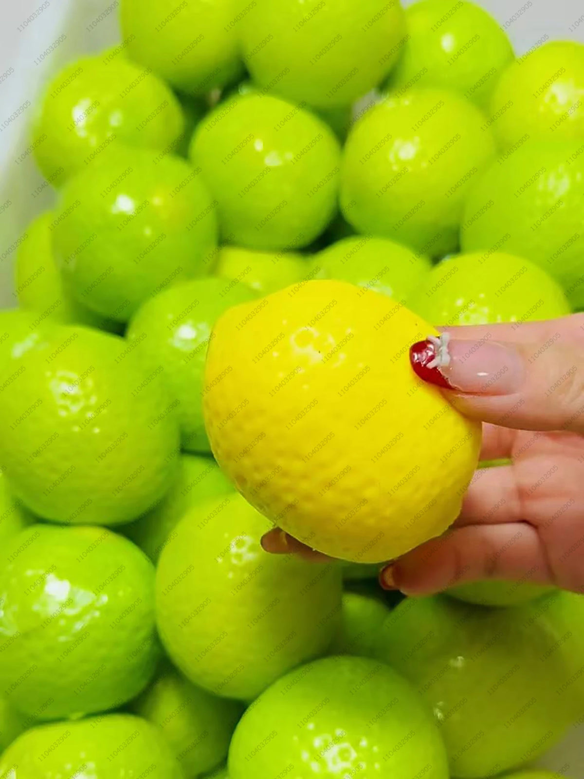 Eine Hand hält einen leuchtend gelben knisternden Kartoffel-Stressball neben grünen.