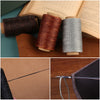Rolls of waxed polyester thread in brown, copper, and gray colors next to a leather sewing kit.