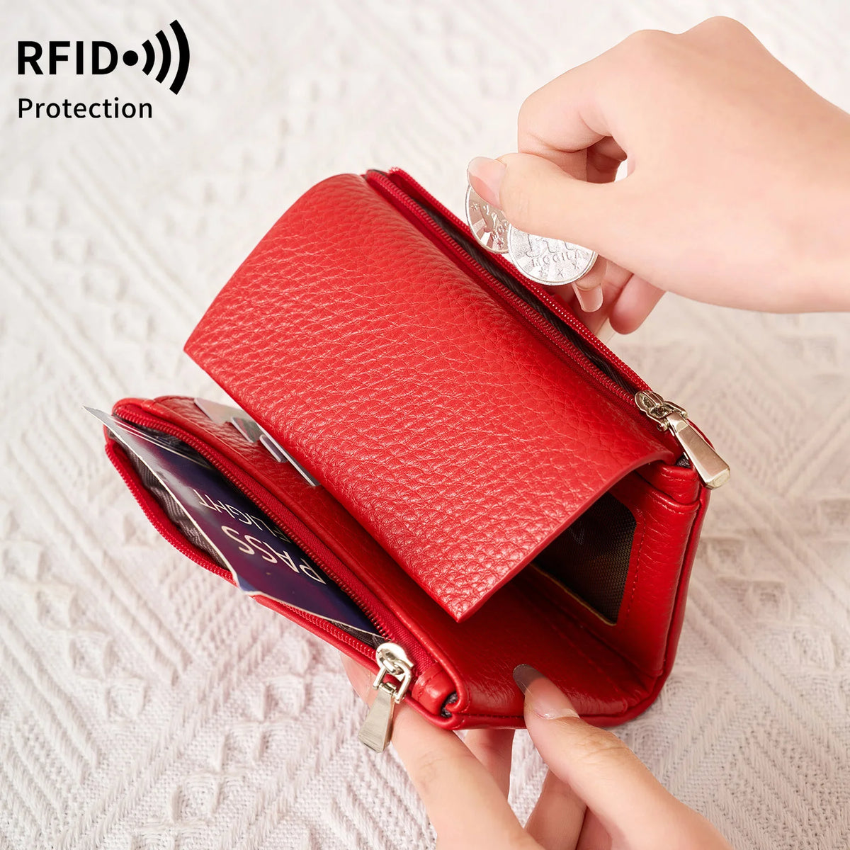 A hand is opening a red RFID-blocking tri-fold wallet with a zipper and coin pocket.