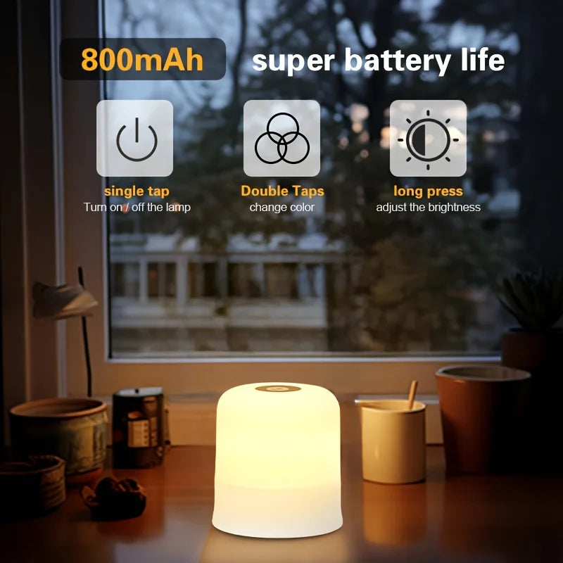 A white touch-activated LED night light is displayed on a wooden table next to various household items.
